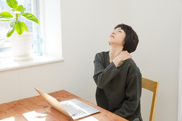 四十肩・五十肩の痛みで肩を押さえる女性