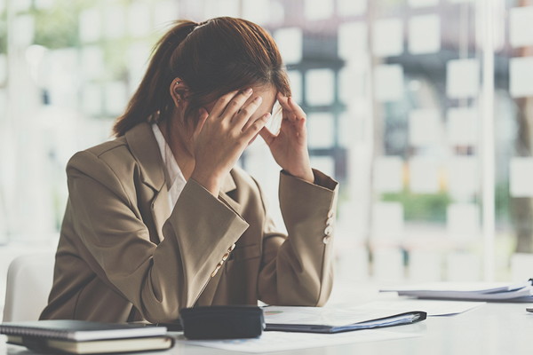 頭を押さえる女性