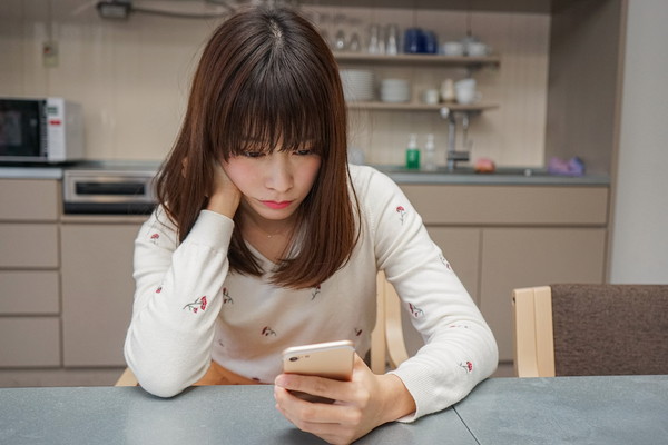 頬杖をついてスマホを触る女性
